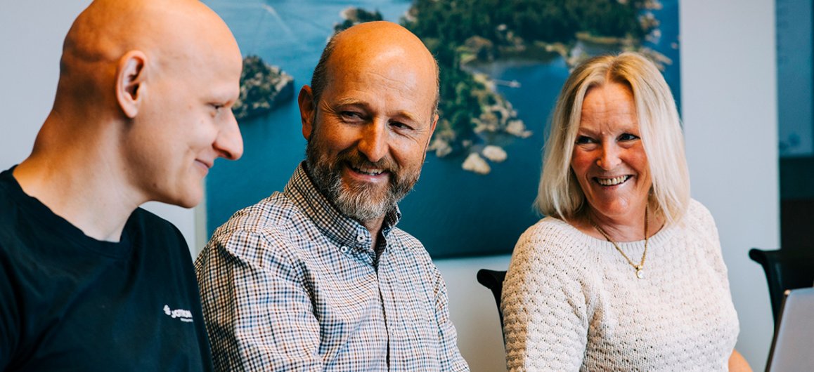 Jotron employees in front of the PC.
