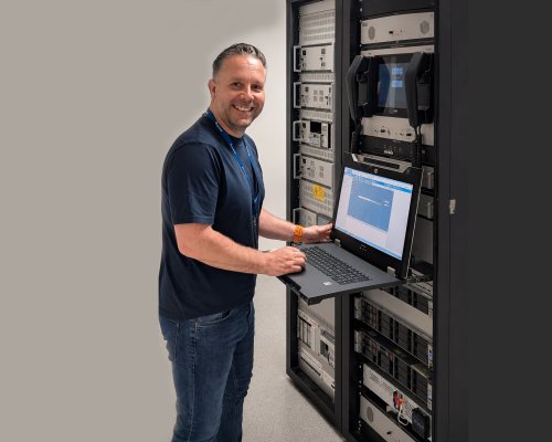 Jotron Product Manager for Ricochet Recorder standing in front of a ATC radio and recorder rack.