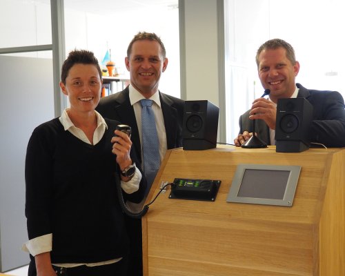 3 Jotron employees in front of Jotron's air traffic control radios