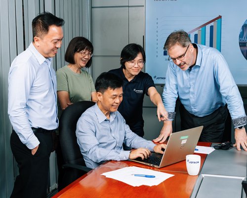 Jotron employees in front of the PC.