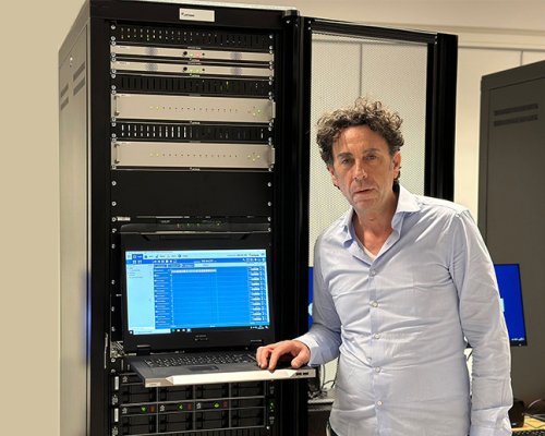 Nenad Jankovic standing in front of a Jotron ATC product rack, showing Ricochet Recorder software on the screen display.