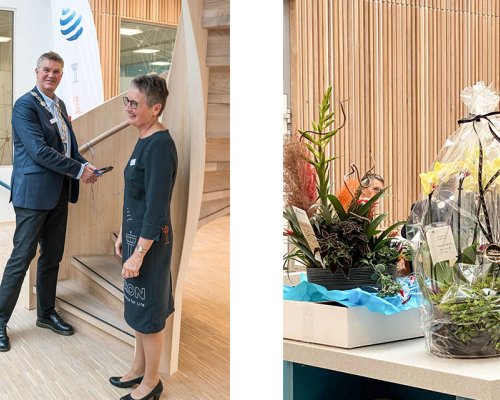 The Mayor of the city of Larvik Erik Bringedal and Merete Berdal open the new Jotron office, in front of a table with flowers and gifts.