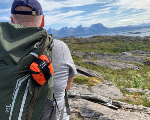 Man on mountain with PLB on his backpack