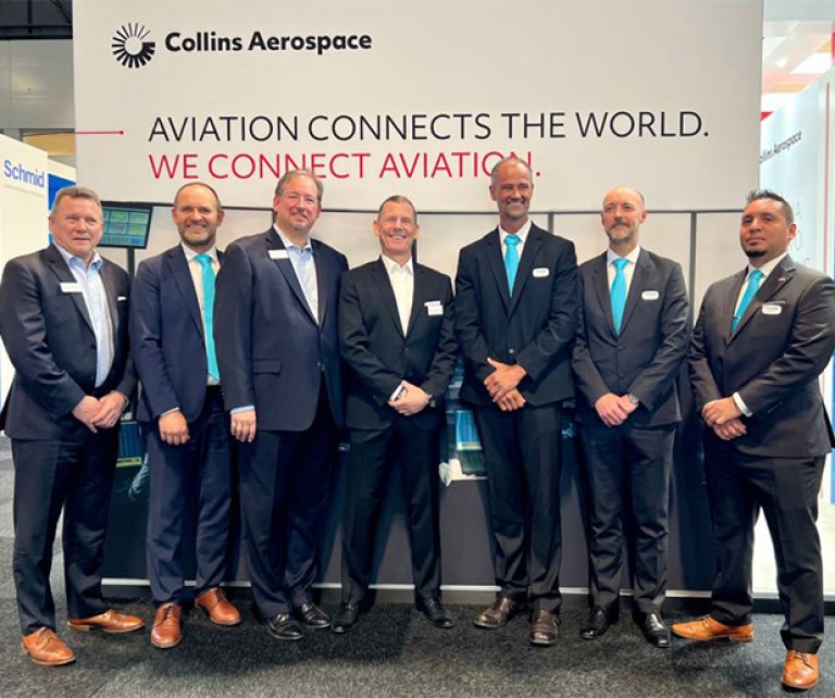 Representatives from Jotron and Collin Aerospace standing in front of Collins Aerospace stand at Airspace World 2022