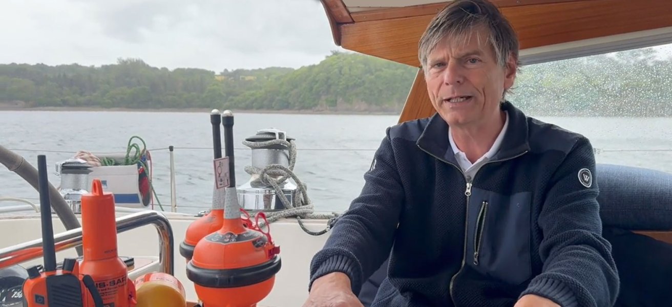 Jotron customer Leon is sitting in his sailboat, showcasing products in Jotron's GMDSS portfolio.