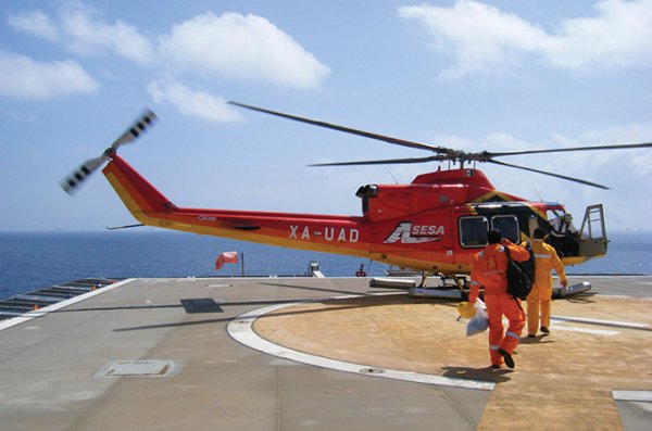 Workers at an oil platform entering a helicopter.